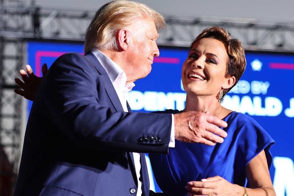 Donald Trump embraces Arizona Republican gubernatorial nominee Kari Lake at a campaign rally at Legacy Sports USA on October 09, 2022, in Mesa, Arizona.