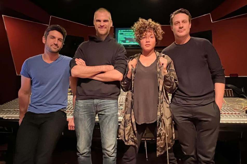 Several members of the band, including Urista, pose in a recording studio.