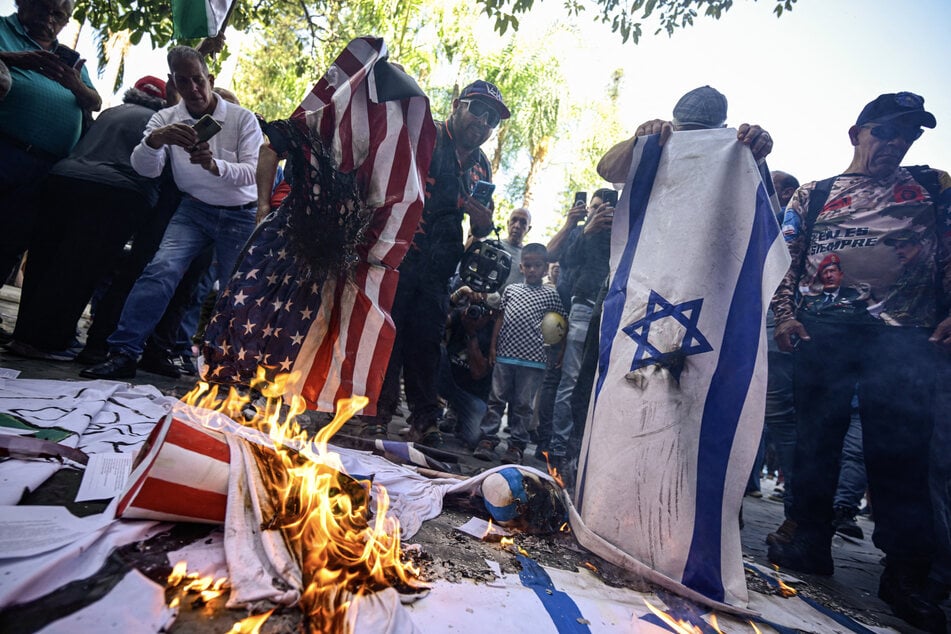Venezuelan protesters burn US and Israeli flags during a rally in Caracas on July 24, 2026.