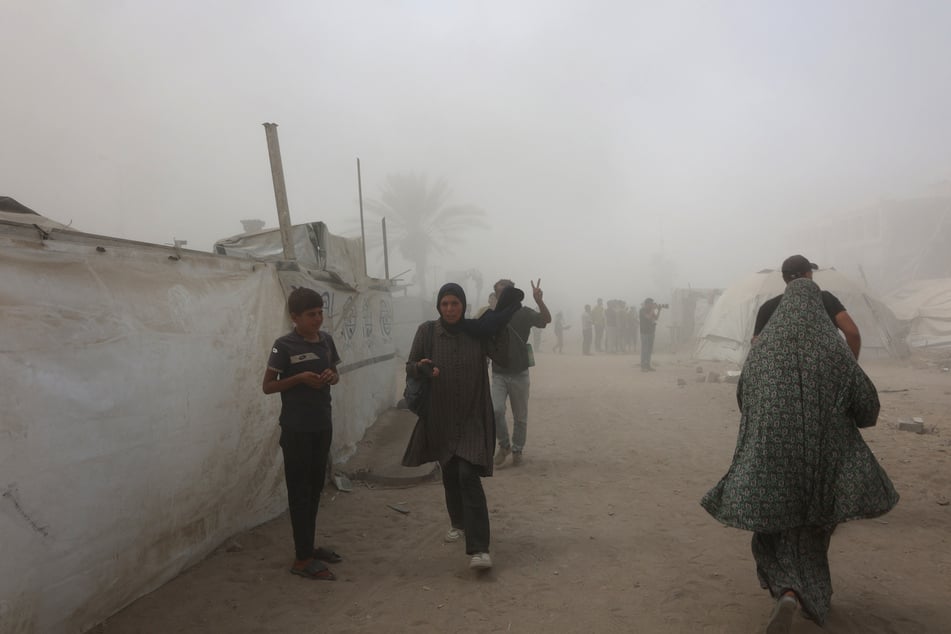 Palestinians evacuate as smoke covers the area after Israel issued evacuation orders ahead of a military strike on the Mushtaha Tower in Gaza City, on September 5, 2025.