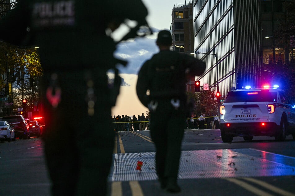 Police officers secure the area as law-enforcement officials visit the crime scene of a shooting in downtown Washington, DC, on Wednesday.