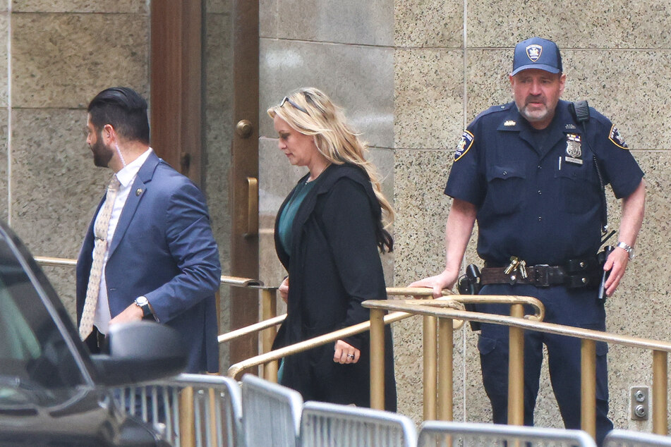 Stormy Daniels (c.) leaves Manhattan Criminal Court after testifying at former US President Donald Trump's trial for allegedly covering up hush money payments linked to extramarital affairs, in New York City on Thursday.