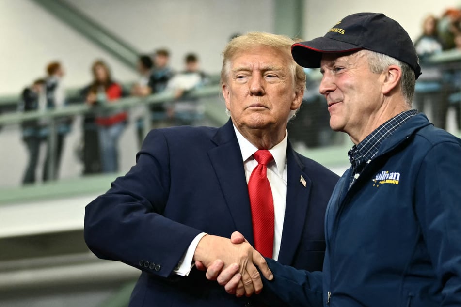 President Donald Trump (l.) shakes hands with Senator Dan Sullivan as he invites him to speak during a campaign rally in Wasilla, Alaska, on October 13. On Friday, the DOJ filed a lawsuit seeking to invalidate the race results if Sullivan loses.