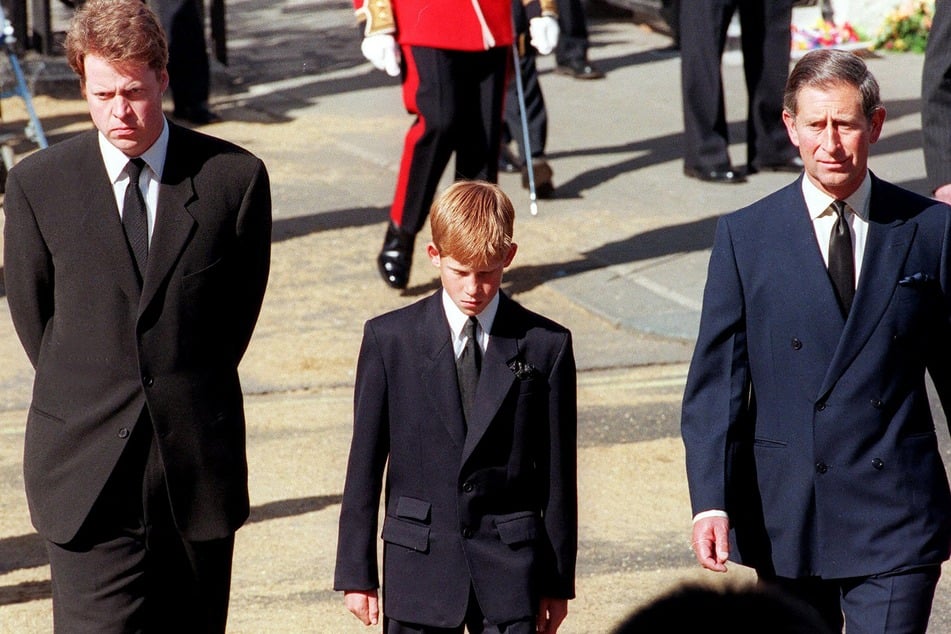 From l. to r.: Earl Spencer, Prince Harry, and then-Prince Charles join the gun carriage carrying Princess Diana's coffin during her funeral in London on September 6, 1997.