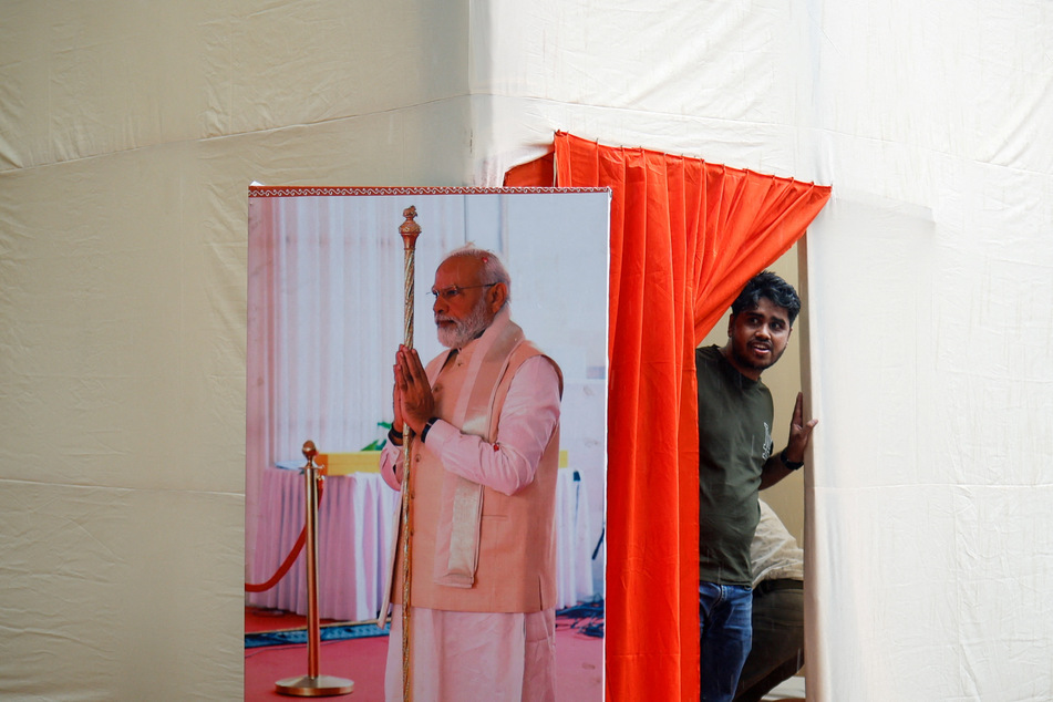 A man stands next to a picture of Indian Prime Minister Narendra Modi at the Bharatiya Janata Party headquarters in New Delhi.