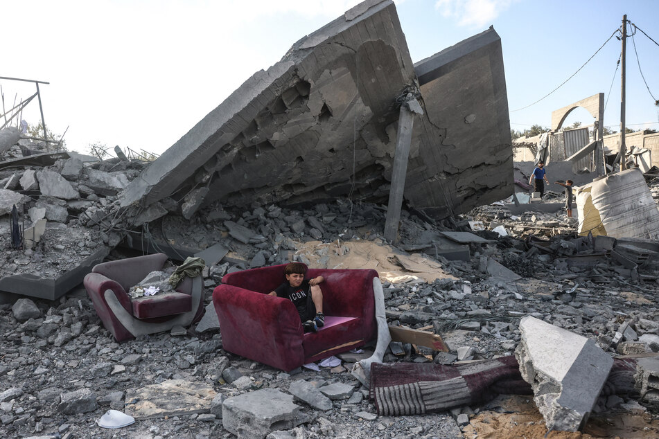 A boy sits on an armchair amid the rubble of a building near the site of an Israeli airstrike in Khan Younis, in the southern Gaza Strip, on June 7, 2026.