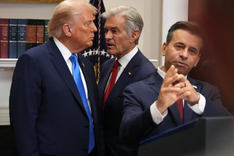 Centers for Medicare and Medicaid Services Administrator Dr. Mehmet Oz (c.) speaks to President Donald Trump (l.) during remarks by then-FDA Commissioner Dr. Marty Makary (r.) in 2025.