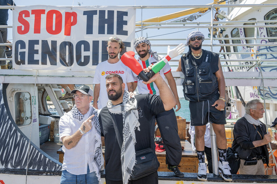 Crew members attend the Freedom Flotilla Handala boat's departure for Gaza at a port in Syracuse, Sicily, southern Italy, on July 13, 2025.