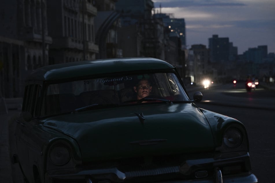 A man sits inside a vintage car during a nationwide blackout in Havana, Cuba, on July 6, 2026.