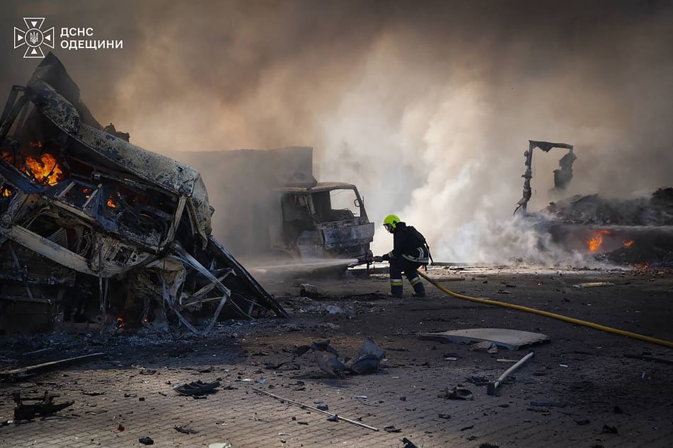 In this Friday handout photo from the Ukrainian Emergency Service, a Ukrainian rescuer works to extinguish a fire at the site of an air attack at an undisclosed location in the Odesa region.