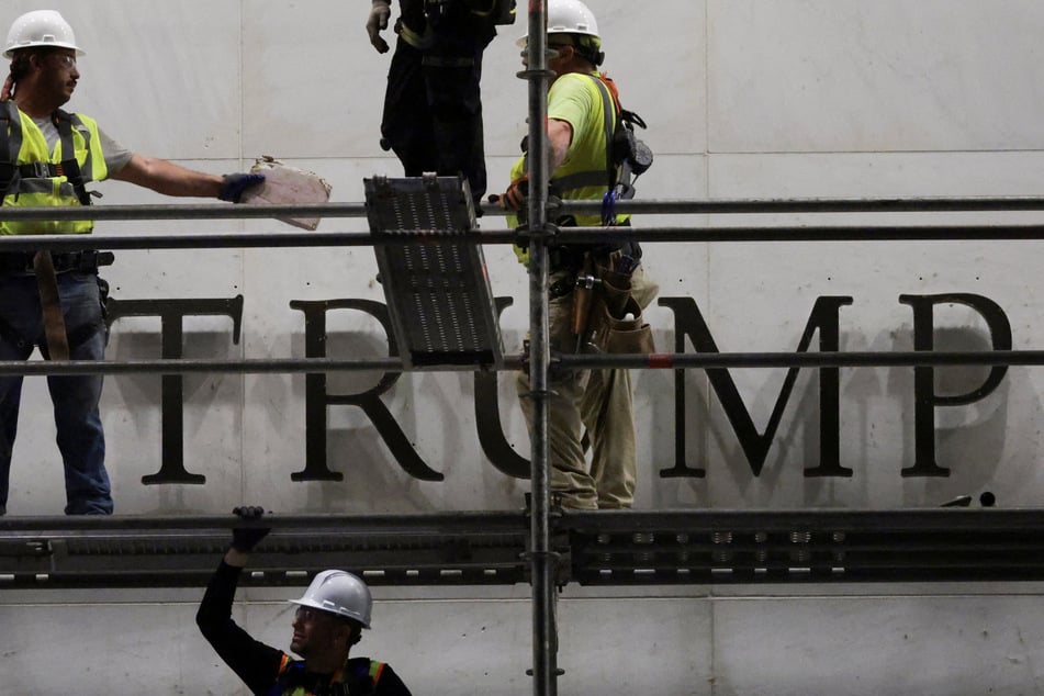Workers prepare scaffolding ahead of removing lettering from the facade of the John F. Kennedy Memorial Center for the Performing Arts, following a federal judge’s order to remove  Donald Trump's name from the institution, on June 13, 2026.