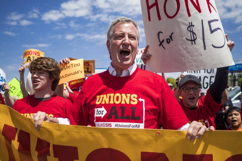 Already in 2019, Bill De Blasio (center) stood with fast food workers, calling on McDonald's to raise its minimum wage to $15 per hour and improve worker safety.