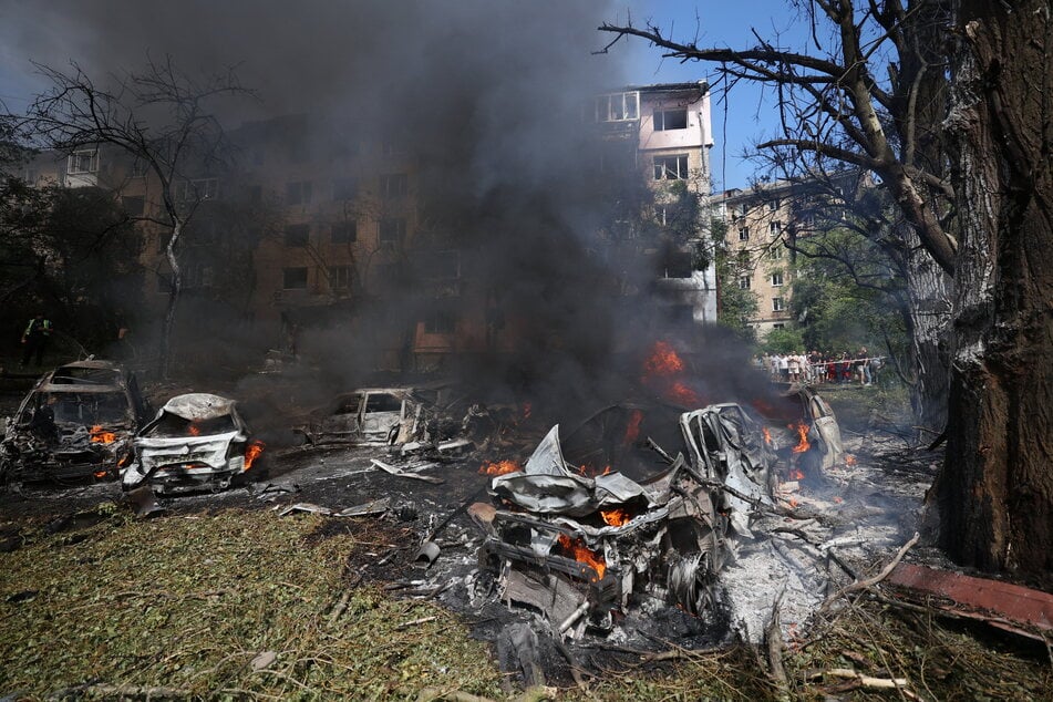 This photograph taken on Monday shows burning cars at the site of a missile attack in Kyiv. Russia launched more than 40 missiles at several cities across Ukraine on Monday in an attack that killed at least 20 people and smashed into a children's hospital in Kyiv, officials said.