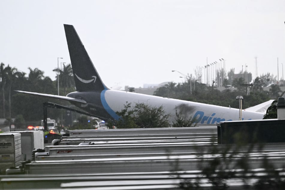 The tail section of an Amazon cargo plane is seen at Miami International Airport after it overran the runway on September 6, 2026. The crash caused the closure of runways and taxiways.