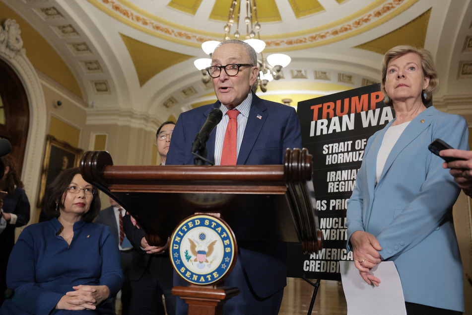 Senate Minority Leader Chuck Schumer (c.) speaks alongside Senator Tammy Baldwin (r.) during a news conference following a weekly Democratic policy luncheon at the US Capitol on April 14, 2026.