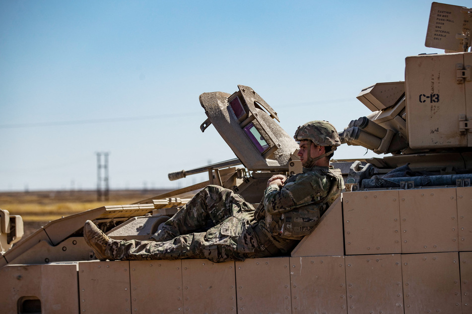 A US soldier rests on a tank as troops patrol oil fields near Syria's northeastern border with Turkey in the Qahtaniyah countryside in the far northeast corner of Hasakeh province on September 3, 2024.