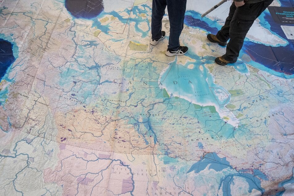 People stand on a giant map of Canada during the 2022 UN Biodiversity Conference in Montreal.