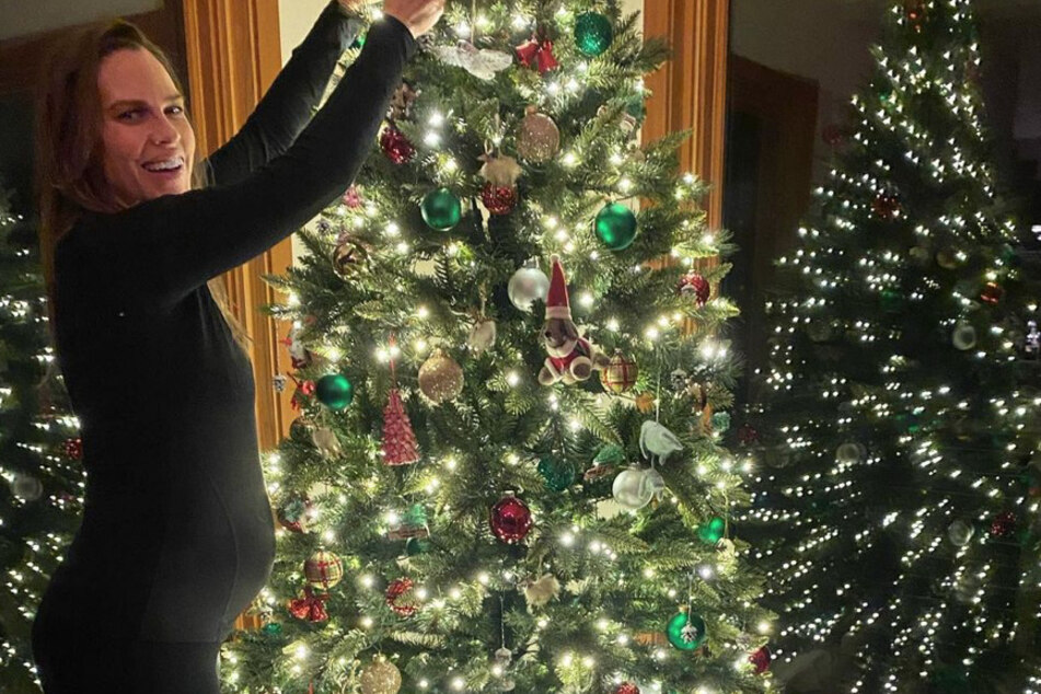 Hilary Swank's growing bump made an appearance in her festive snap of her heavily decorated Christmas tree!