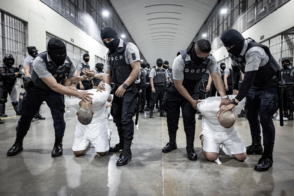 Salvadoran police officers escort Venezuelans recently deported by the US government to be imprisoned in the Terrorism Confinement Center prison.