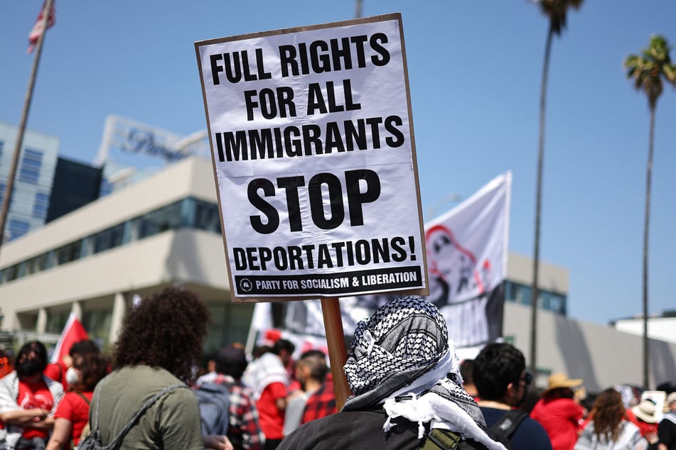 A demonstrator holds a sign reading "Stop Deportations" during a May Day march through Hollywood.