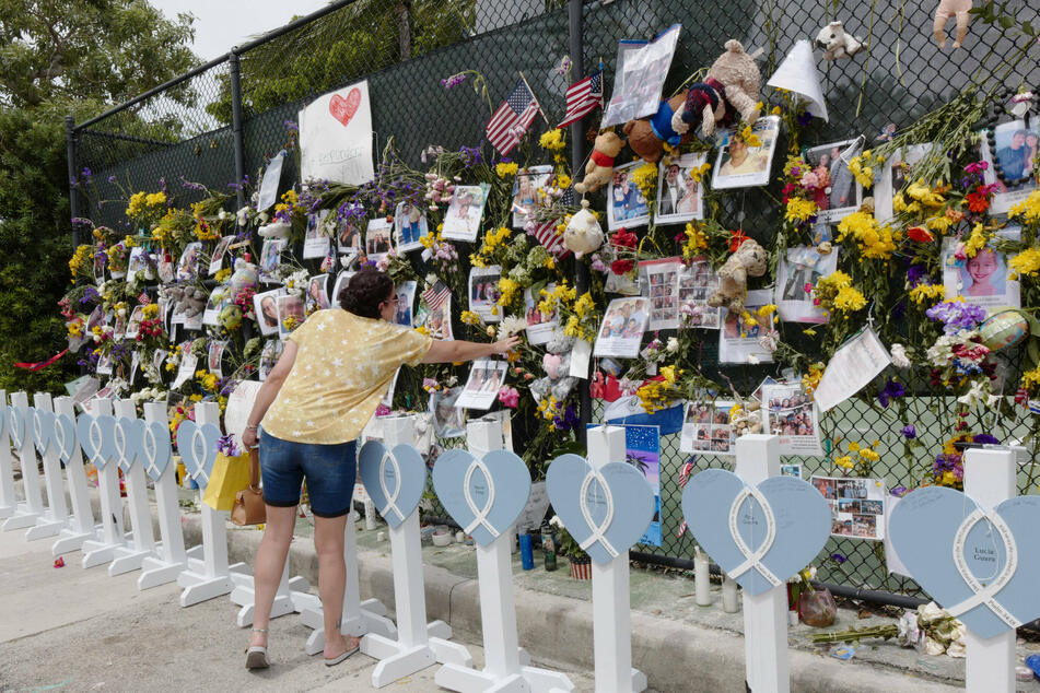 Vistors placed flowers and said prayers for the missing victims at the memorial outside St. Joseph Catholic Church near the collapsed Champlain Towers South condo in Surfside, Florida.