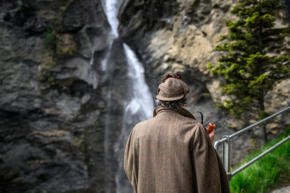 British motoring author Philip Porter, dressed as Sherlock Holmes, faces the Reichenbach Falls in Switzerland during a visit by members of the Sherlock Holmes Society of London on May 3, 2026.