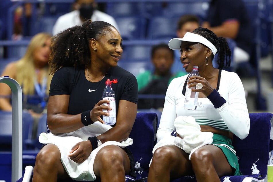 Serena Williams (l) and Venus Williams (r) look on during a changeover against Lucie Hradecka and Linda Noskova of Czech Republic during the Women’s Doubles First Round match on Day Four of the 2022 US Open on September 1, 2022 in New York.