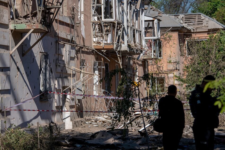 Ukrainian law enforcement officers work next to a damaged residential building following an air attack in Dnipro on June 2, 2026.