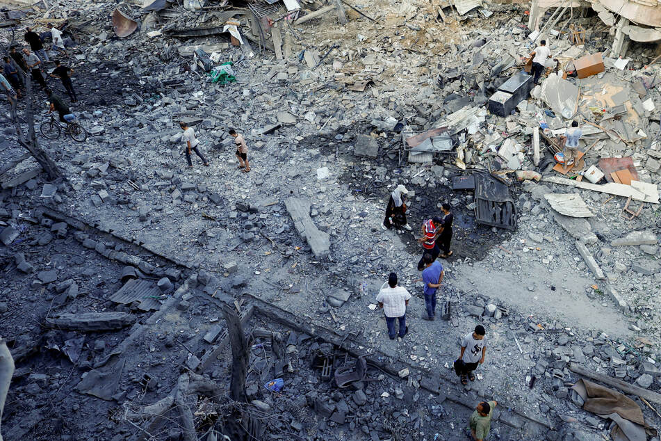 Palestinians inspect a site of an Israeli strike on a house in Deir Al-Balah, central Gaza Strip, on Wednesday.