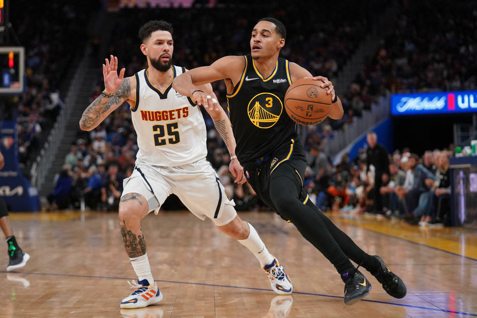 The Warriors' Jordan Poole (r.) dribbles past Nuggets guard Austin Rivers.