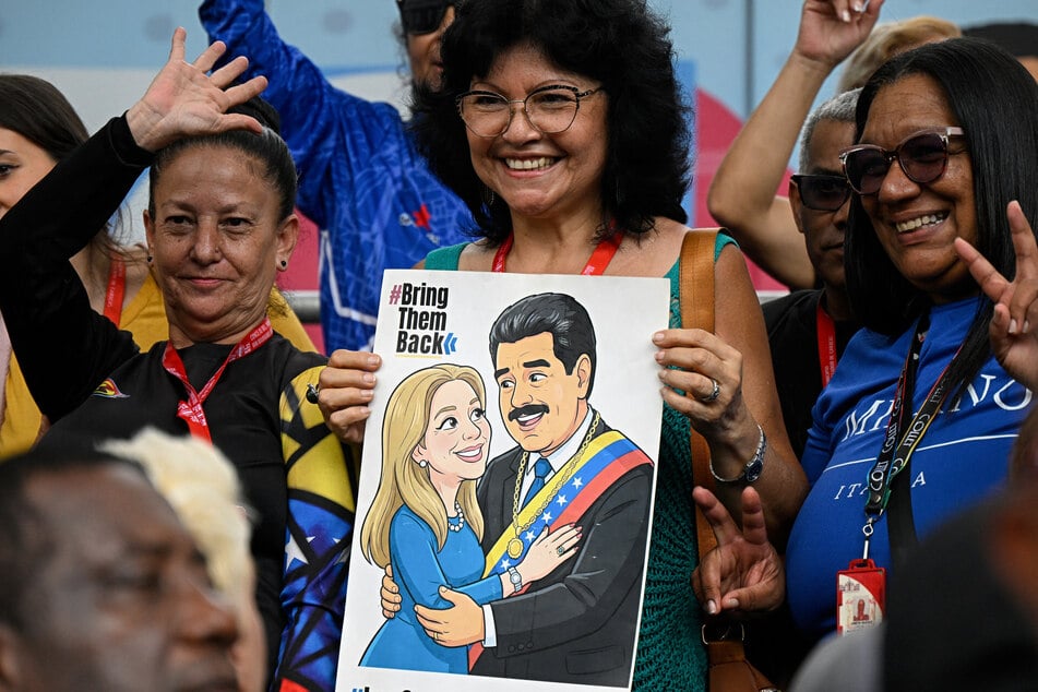 A supporter of Venezuela's government holds a poster calling for the return of President Nicolas Maduro and First Lady Cilia Flores during a march in Caracas on October 13, 2026.