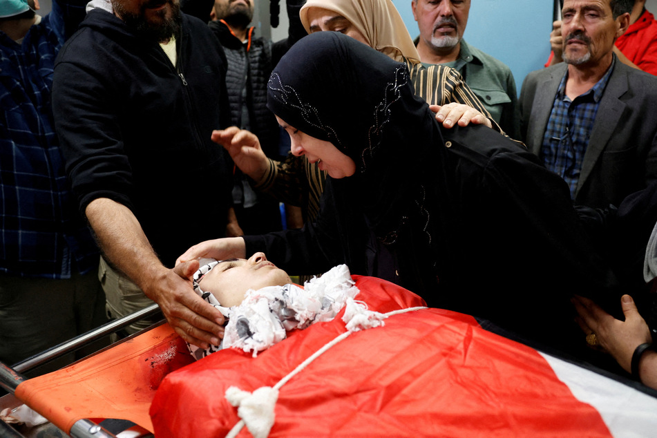 The mother of Palestinian-American 14-year-old Omar Mohammad Rabea, who was killed by Israeli forces in Turmus Ayya, mourns next to his body at a hospital on April 6, 2025.