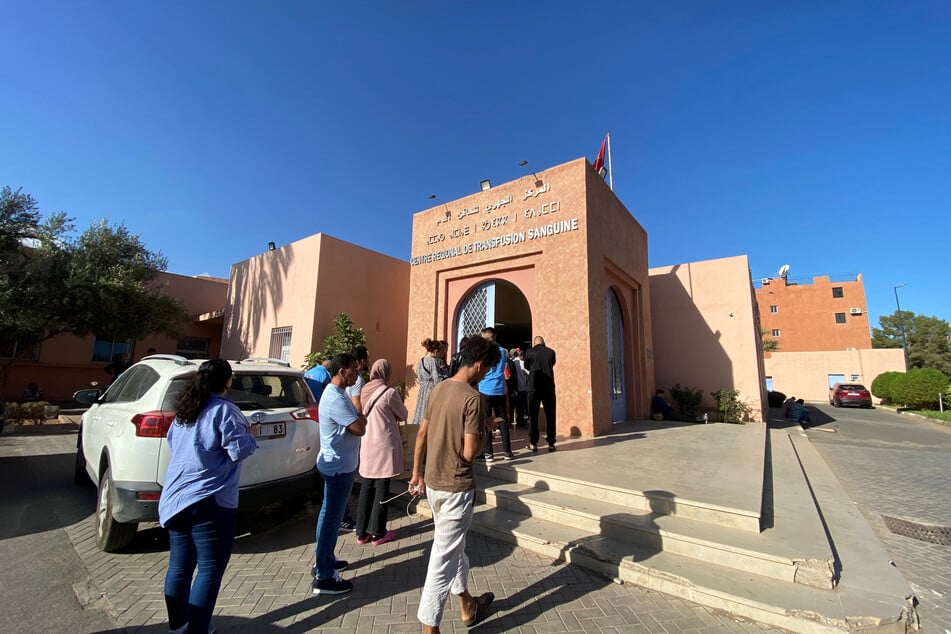 People queue in front of a blood transfusion center, answering the call to do donate blood for injured victims.