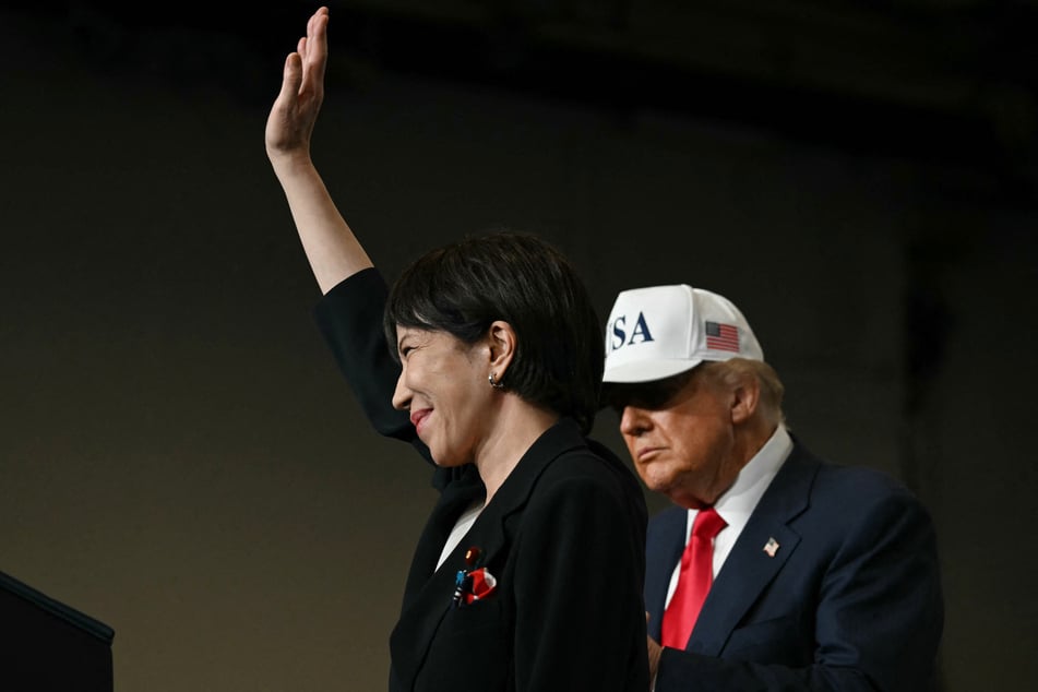 President Donald Trump (r.) looks on as Japan's Prime Minister Sanae Takaichi waves after speaking in front of US Navy personnel at the US naval base in Yokosuka on October 28, 2025.