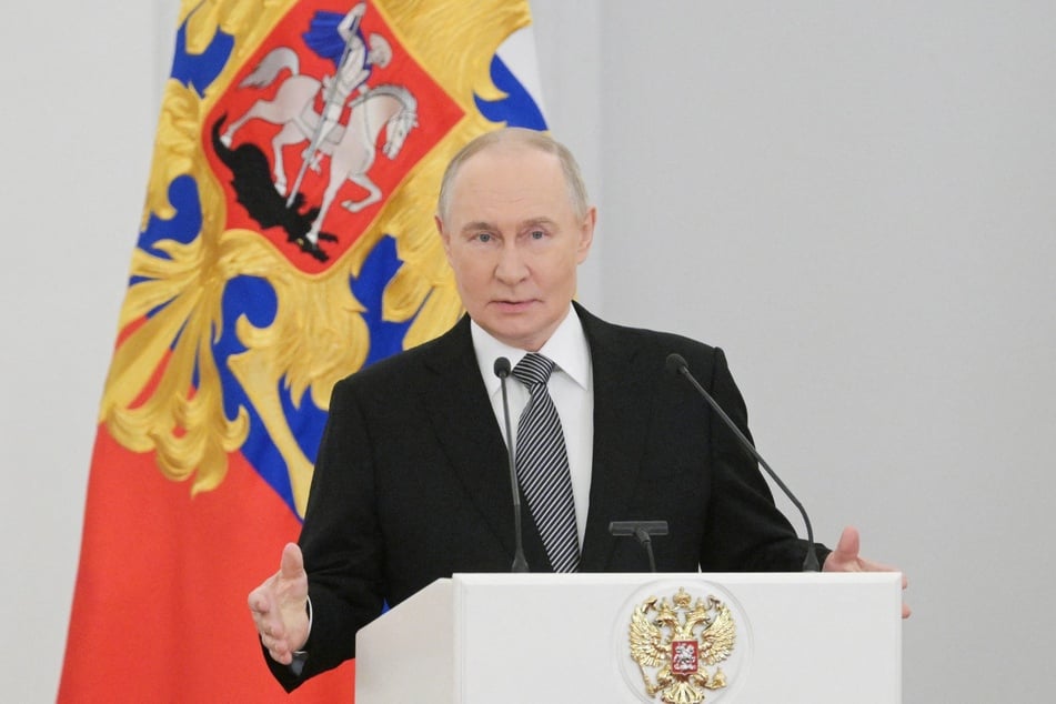 In this pool photograph distributed by the Russian state agency Sputnik, Russia's President Vladimir Putin gives a speech during a ceremony to celebrate Heroes of the Fatherland Day at the Kremlin in Moscow on December 9, 2025.