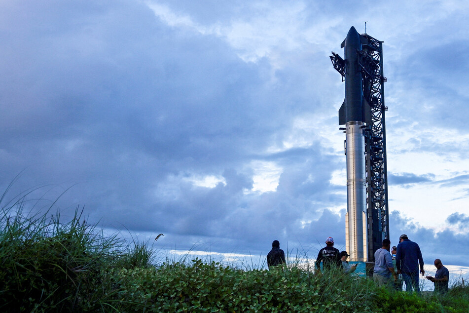 Spectators watch from the dunes as preparations to launch a SpaceX Starship spacecraft continue, at the company's complex in Texas on August 25, 2025.