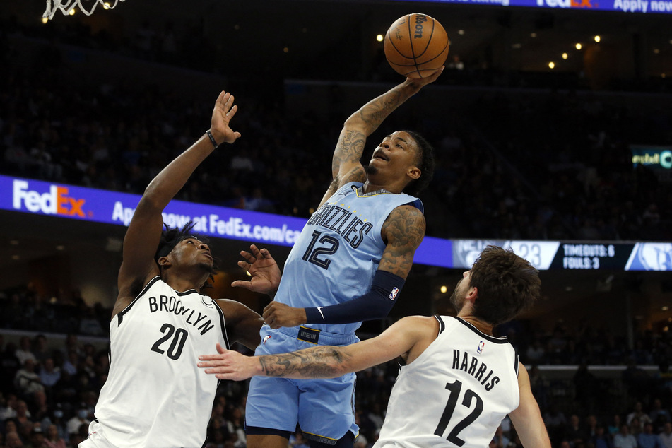 Memphis Grizzlies guard Ja Morant drives to the basket over Brooklyn Nets center Day'Ron Sharpe and forward Joe Harris at FedExForum.