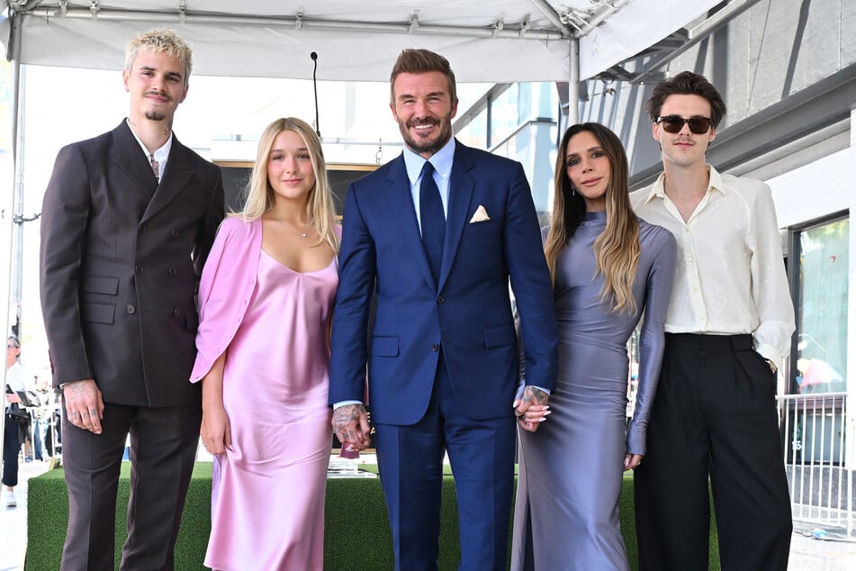 David Beckham (c.) is joined by his wife Victoria (second from r.) and their children Romeo (l.), Harper (second from l.), and Cruz at his Hollywood star ceremony.
