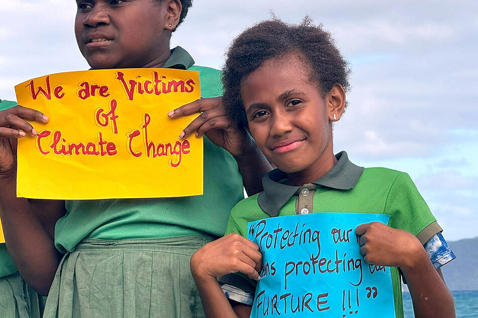 Children from the Suango Mele primary and secondary school, located north of the Vanuatu capital of Port Vila, hold signs against climate change on July 24, 2025.