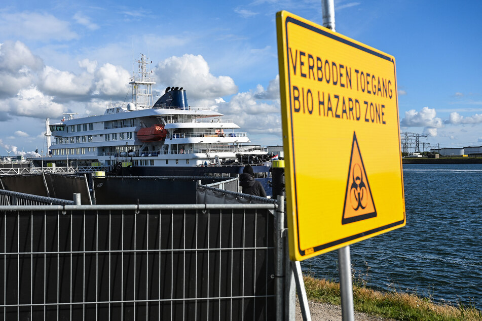 This photograph shows a view of a placard reading "Bio hazard zone" with a view of the Dutch Hantavirus-hit cruise ship MV Hondius in the background, docked at the port of Rotterdam on Monday.