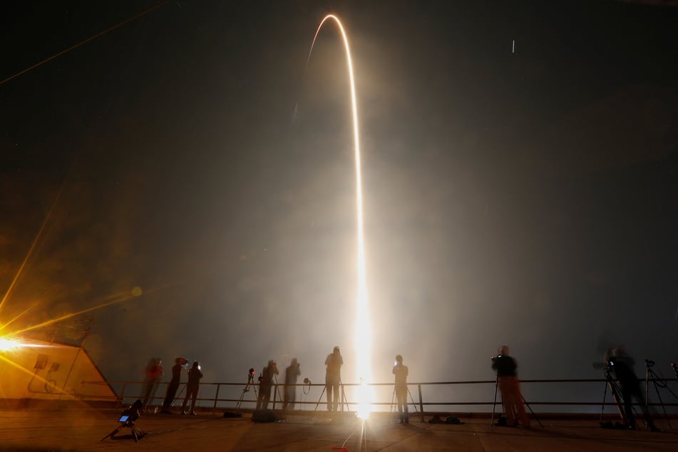 People watch as the Crew-7 mission blasts off into space from Cape Canaveral, Florida.