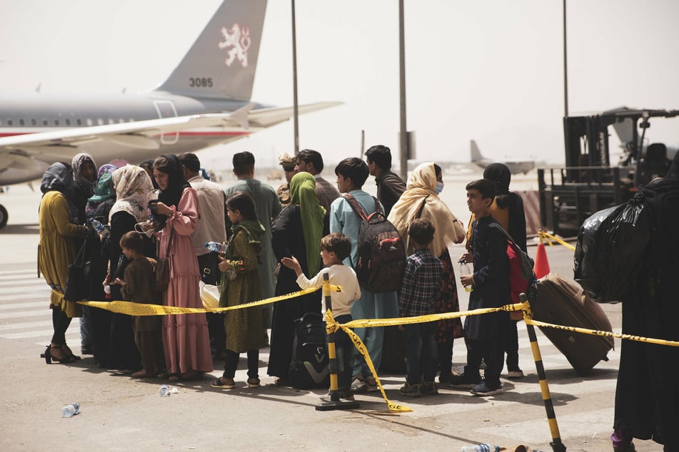 People wait to board a plane in Kabul as part of Operation Allies Refuge.