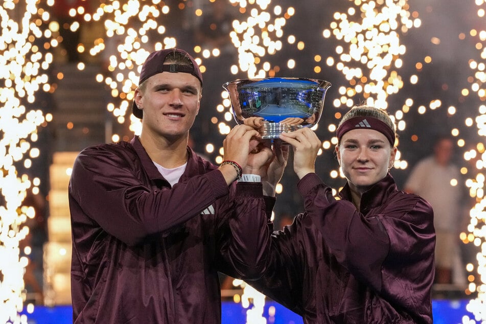 The Czech Republic's Jakub Mensik (l.) and Karolina Muchova (r.) hold up the trophy after winning the mixed doubles final tennis match at the US Open on August 26, 2026.