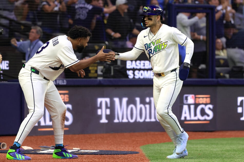Tampa Bay Rays outfielder Victor Mesa Jr. (r.) celebrates with third baseman Junior Caminero (l.) after scoring a run against the Cleveland Guardians during the fourth inning in game two of the ALCS.