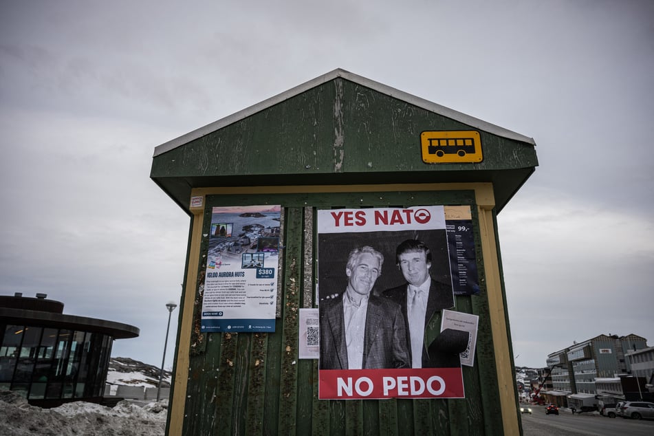 A poster showing Jeffrey Epstein (l.) and President Donald Trump with the text “YES NATO NO PEDO” is seen at a bus stop in Nuuk, Greenland, on January 24, 2026. Greenland's prime minister touted the nation's agreement with the US