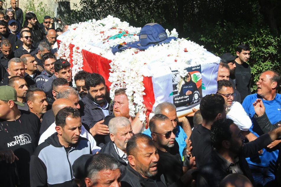 Mourners carry the coffin of Lebanese journalist Amal Khalil during her funeral procession in Bissariye town, south of Sidon, on April 23, 2026.
