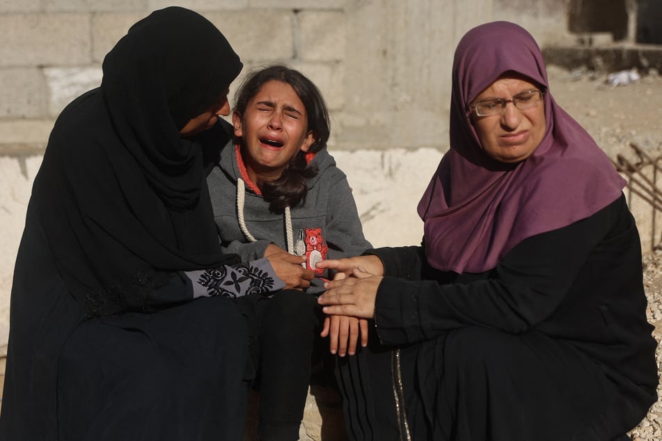 A displaced Palestinian girl mourns her mother, killed in Israeli strikes, at Al-Shifa Hospital in Gaza City on November 20, 2025.
