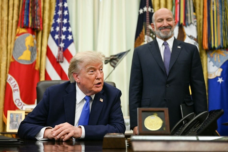 Secretary of Commerce Howard Lutnick (r.) looks on as President Donald Trump speaks after signing executive orders in the Oval Office on August 6. The president has stood by Lutnick, despite the controversy over his ties to Epstein.