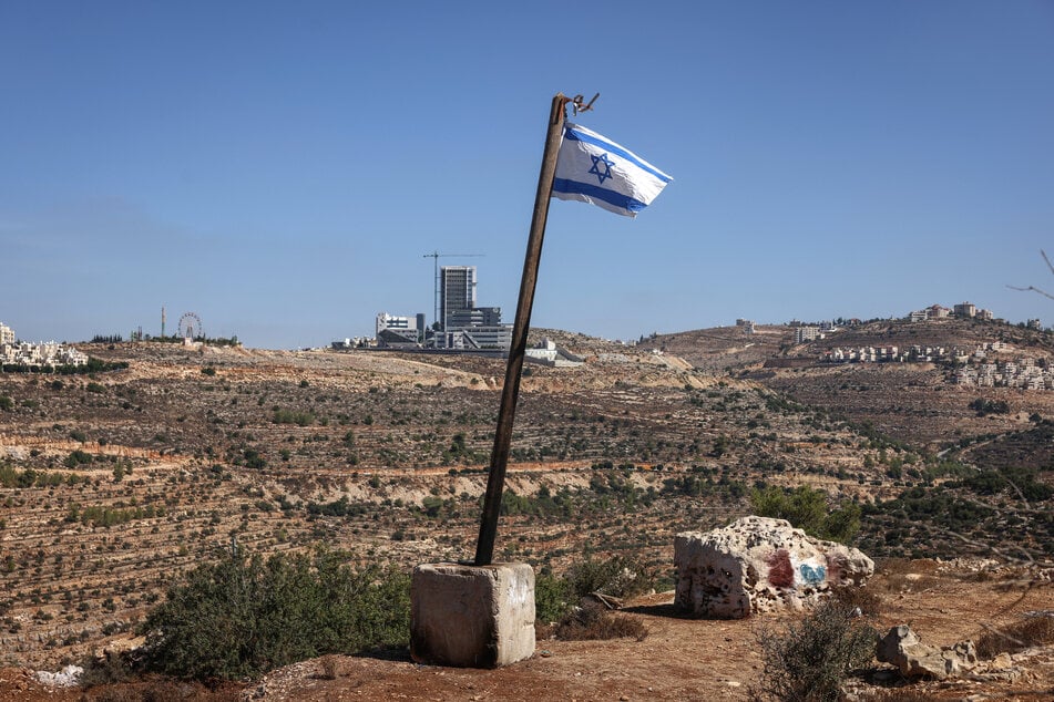 An Israeli flag installed by the settlers is pictured at the western entrance to Ramallah, in the Israeli-occupied West Bank on September 27, 2026. Israel's far-right finance minister Bezalel Smotrich called for Israeli forces to "go to war" against Palestinians in the West Bank.