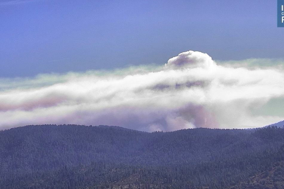 Smoke rises from hills as the Washburn Fire burns in California.